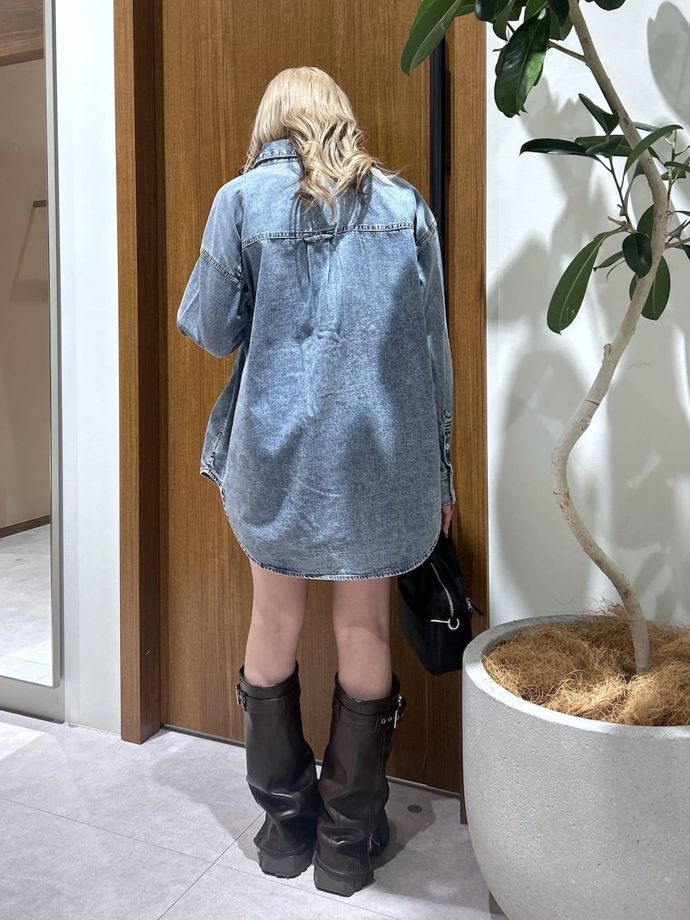 ブラック系のハンドバッグ、ブルー系のシャツ/ブラウスを着用したレディースの冬コーディネートの3枚目の写真