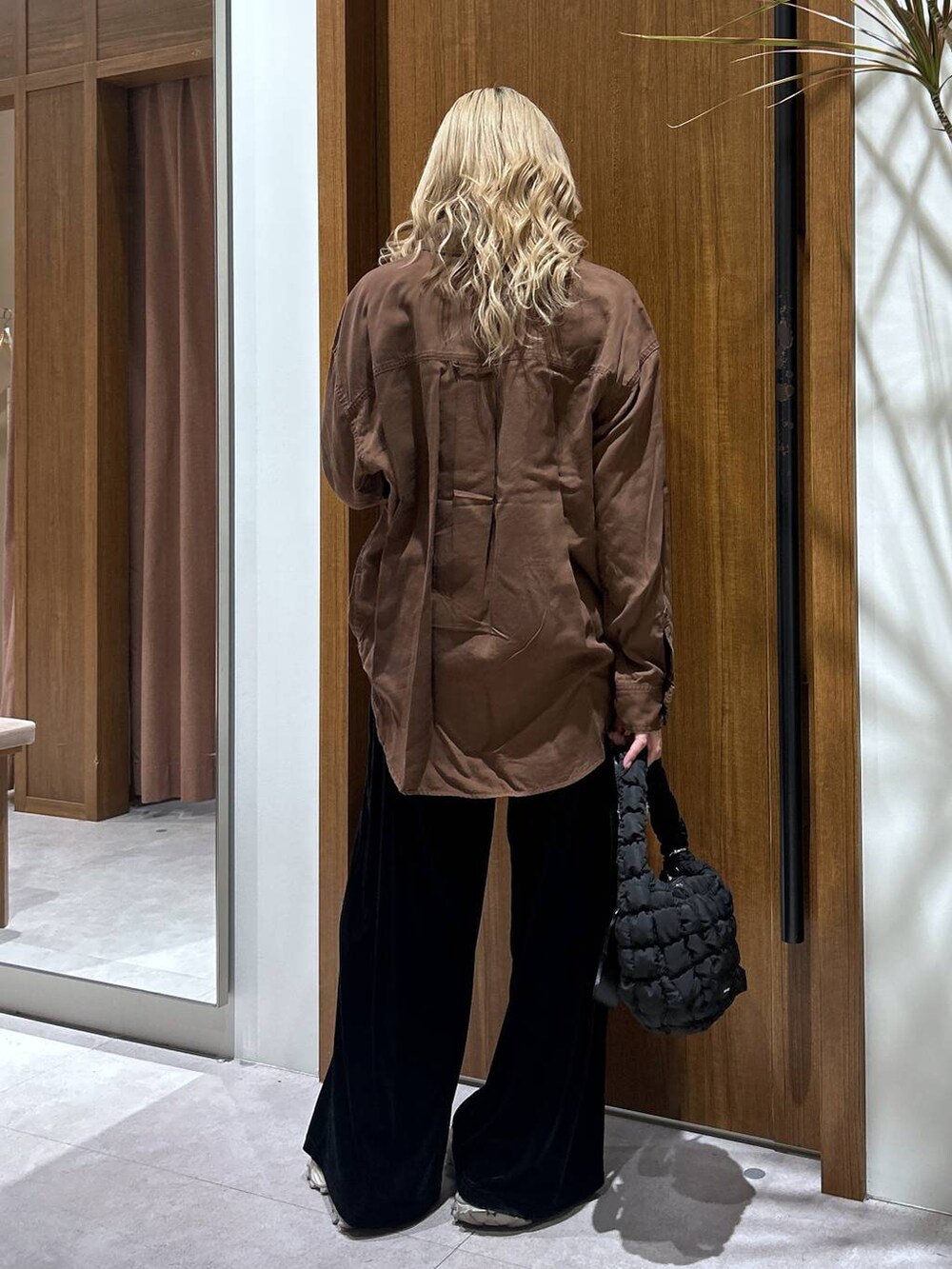 ブラック系のハンドバッグ、ブラウン系のシャツ/ブラウス、ブラック系のその他パンツを着用したレディースの秋コーディネートの3枚目の写真