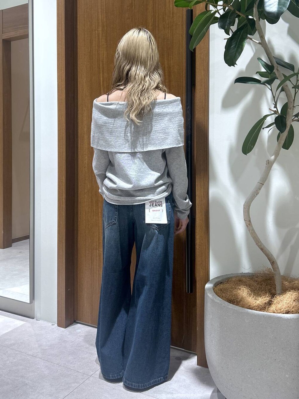 ブルー系のデニムパンツ、グレー系のニット/セーターを着用したレディースの春コーディネートの3枚目の写真