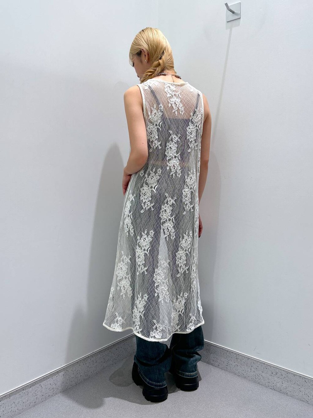 ブルー系のデニムパンツ、ホワイト系のベストを着用したレディースの夏コーディネートの3枚目の写真