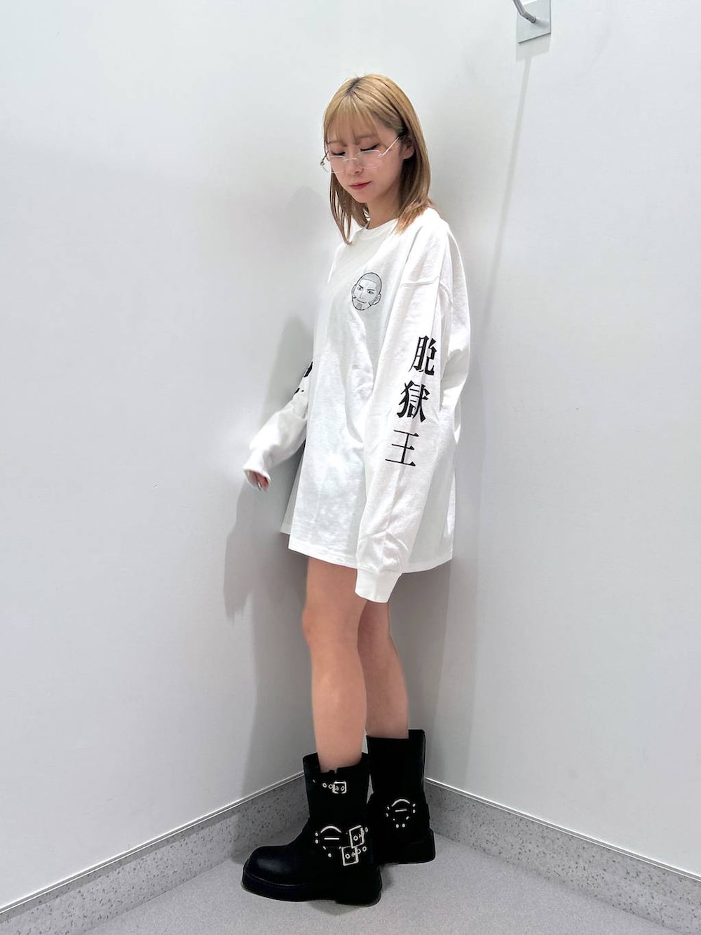 ブラック系のその他パンツ、ブラック系のブーツ、ホワイト系のTシャツ/カットソーを着用したレディースの冬コーディネートの2枚目の写真