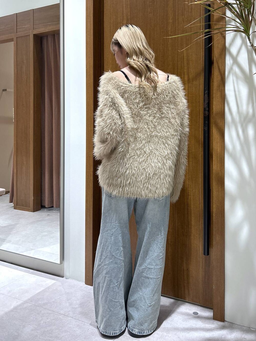 ブラック系のブーツ、ブルー系のデニムパンツ、ベージュ系のニット/セーターを着用したレディースの秋コーディネートの3枚目の写真