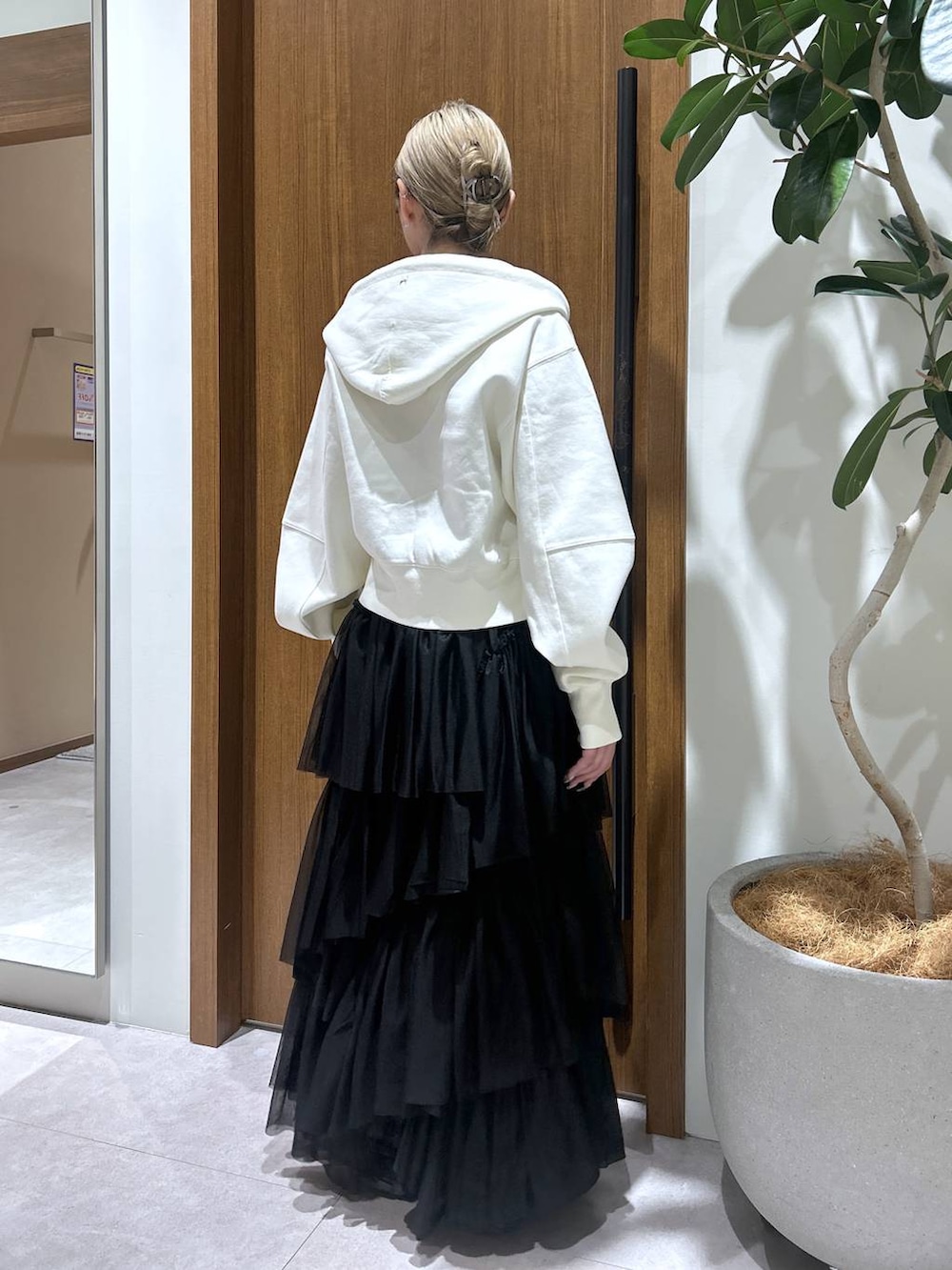 ブラック系のスカート、ベージュ系のパーカーを着用したレディースの春コーディネートの3枚目の写真