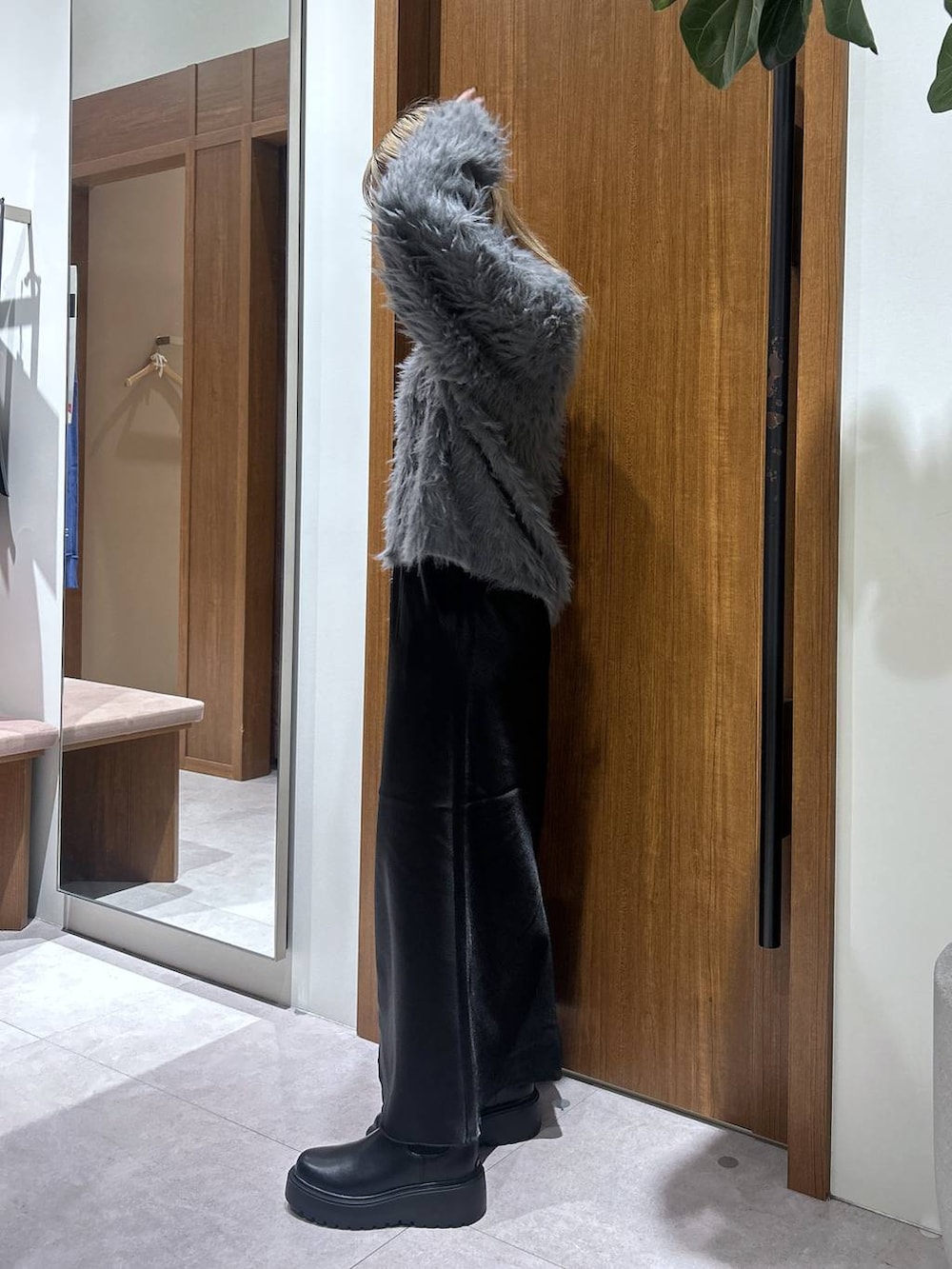 グレー系のカーディガン/ボレロ、ブラック系のブーツ、ブラック系のハンドバッグを着用したレディースの秋コーディネートの2枚目の写真