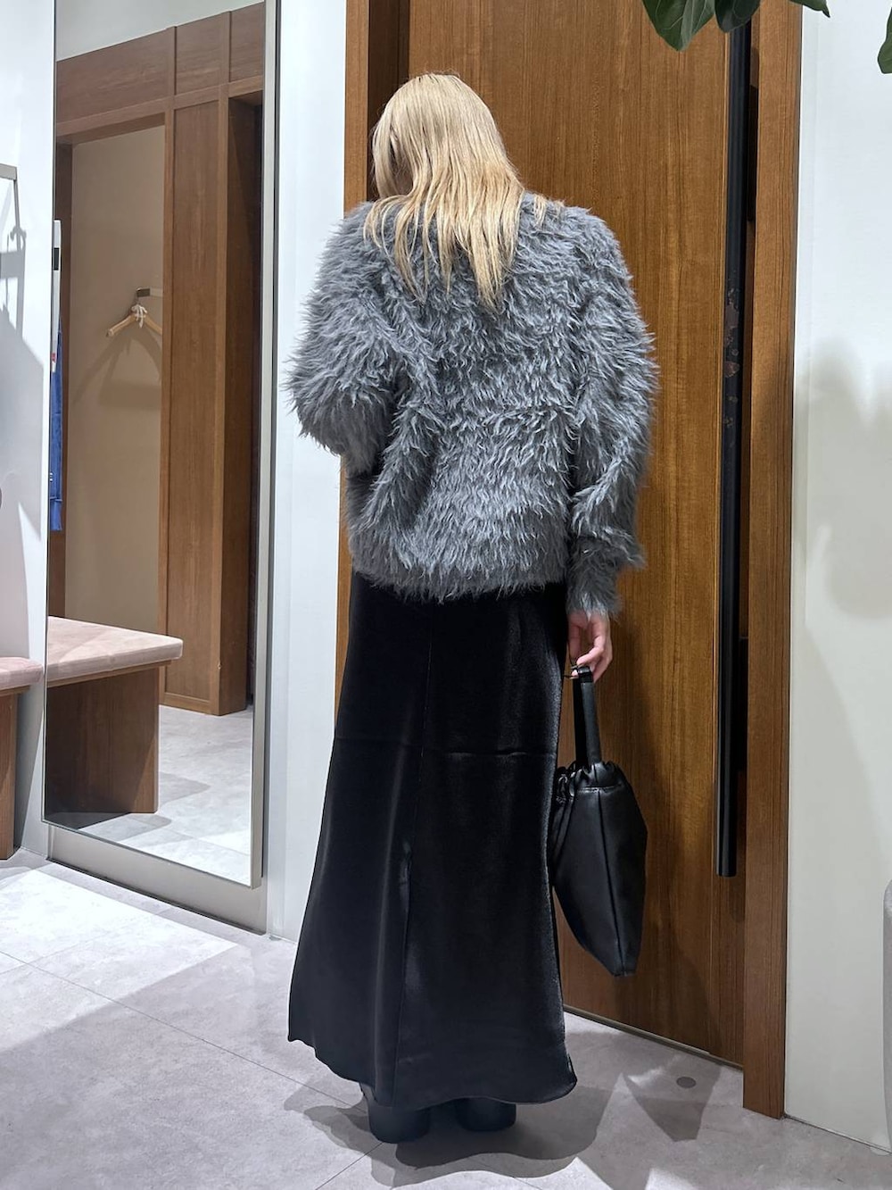 グレー系のカーディガン/ボレロ、ブラック系のブーツ、ブラック系のハンドバッグを着用したレディースの秋コーディネートの3枚目の写真