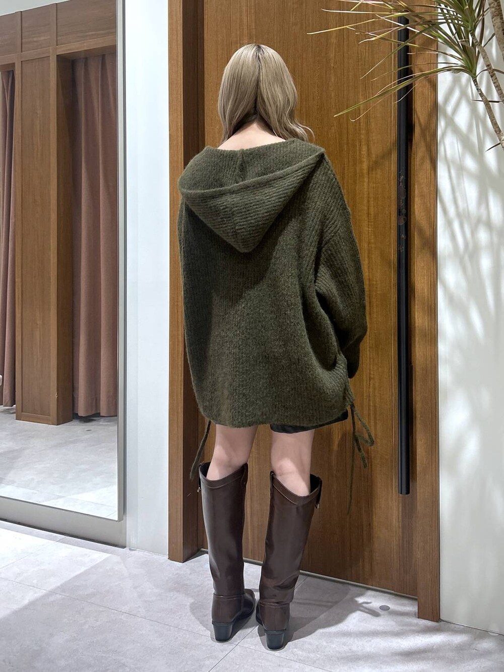 ブラウン系のブーツ、ブラック系のその他パンツ、グリーン系のニット/セーターを着用したレディースの冬コーディネートの3枚目の写真