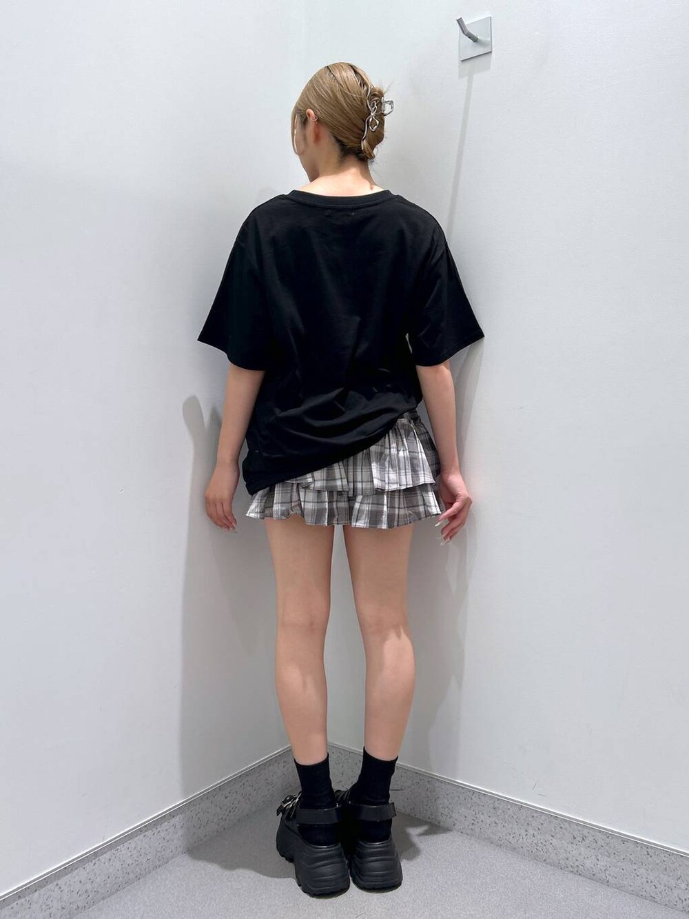 ブラック系のサンダル、ブラック系のTシャツ/カットソー、グレー系のスカートを着用したレディースの夏コーディネートの3枚目の写真