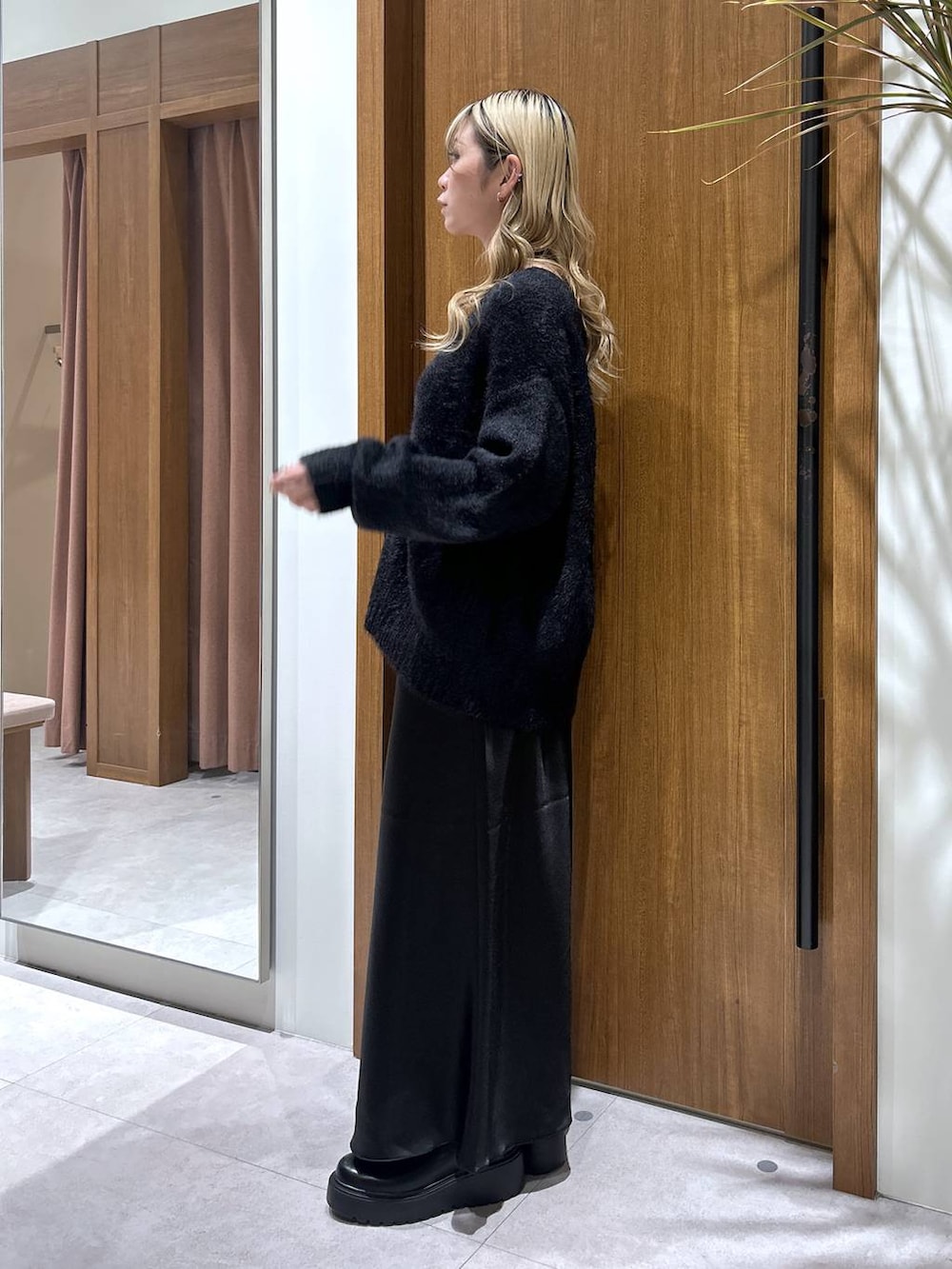 ブラック系のブーツ、ブラック系のスカート、ブラック系のカーディガン/ボレロを着用したレディースの秋コーディネートの2枚目の写真