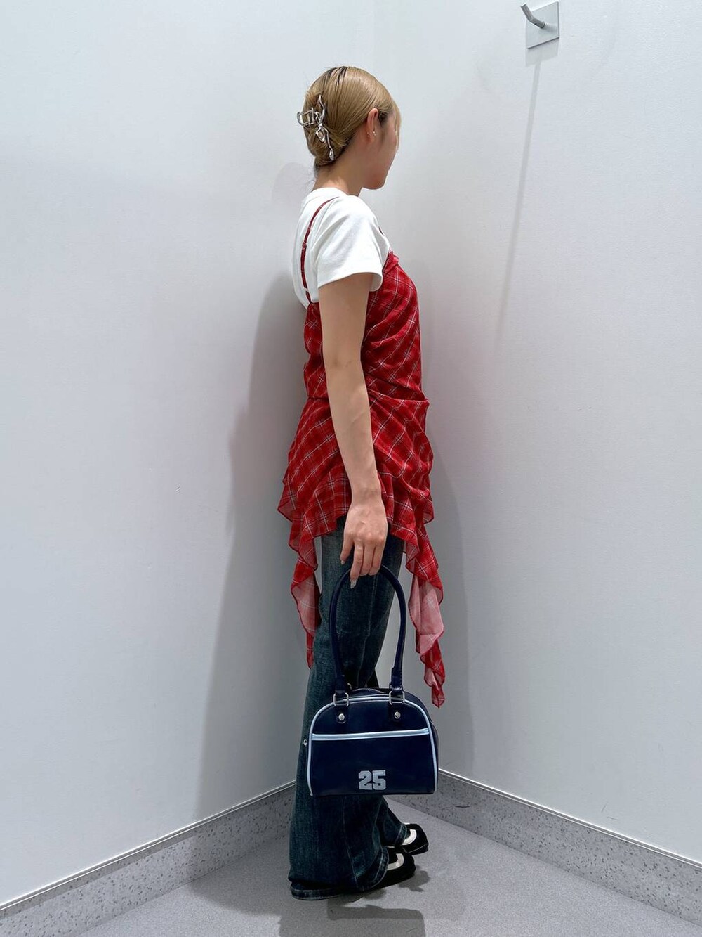 ブルー系のデニムパンツ、ブルー系のボストンバッグ、ブラック系のパンプスを着用したレディースの夏コーディネートの2枚目の写真