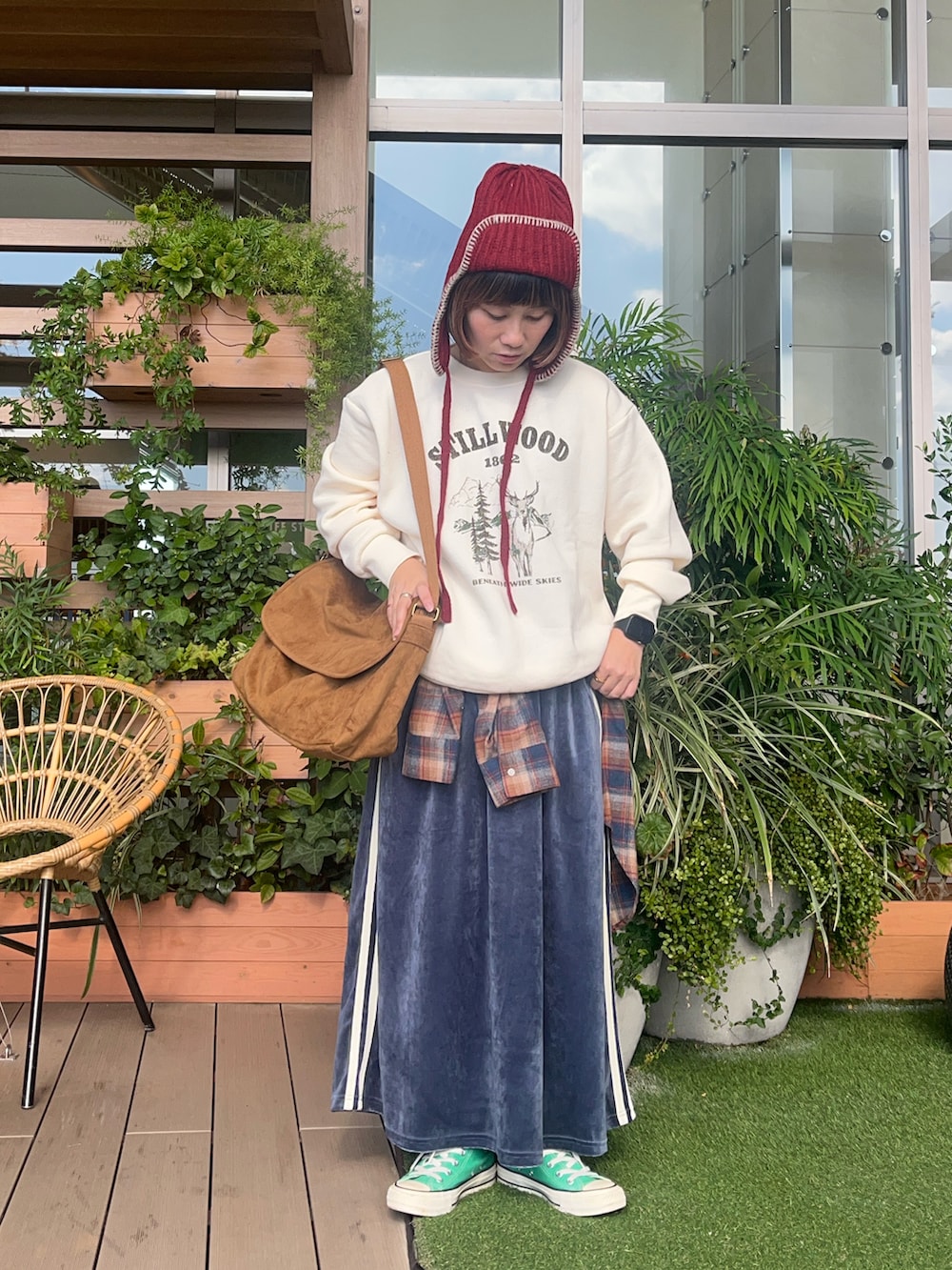 レッド系の帽子を着用したレディースの春コーディネートの2枚目の写真