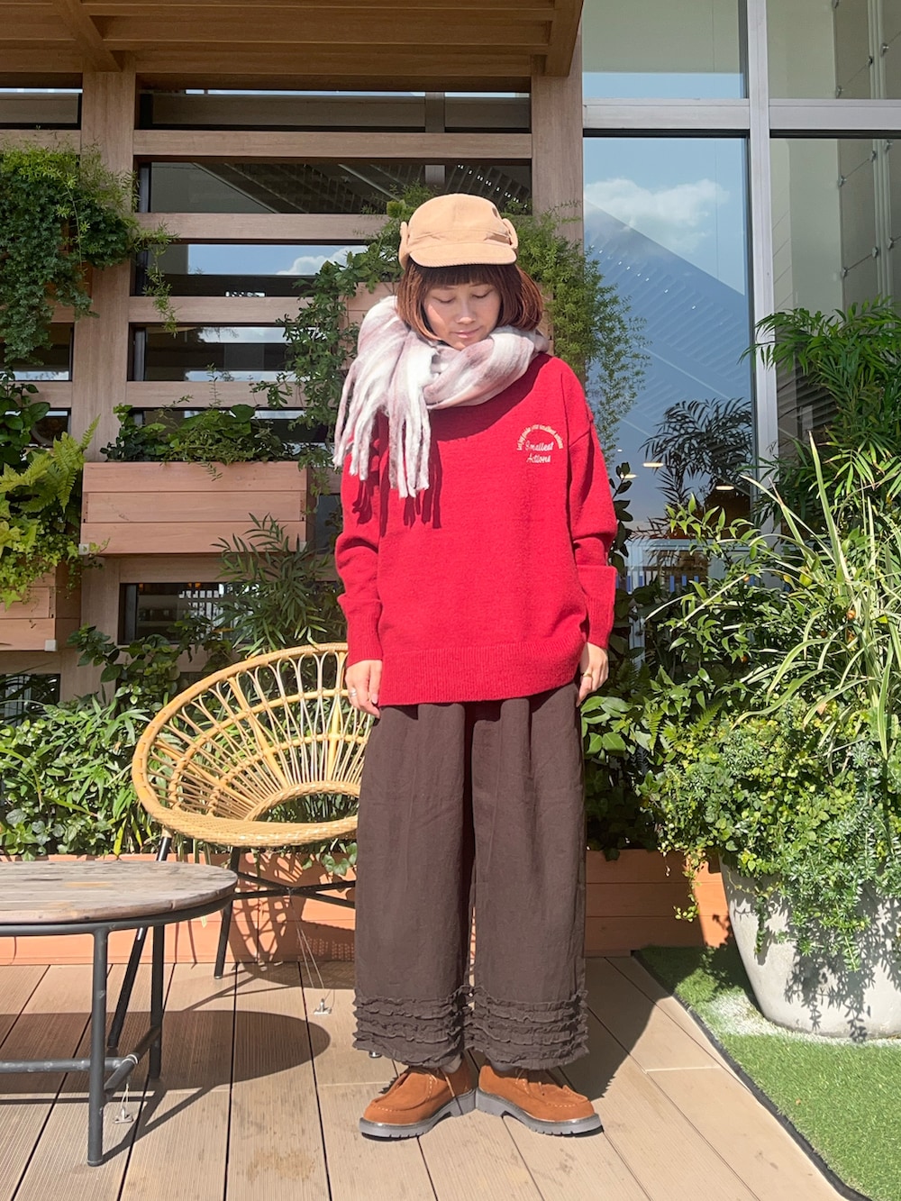 レッド系のニット/セーターを着用したレディースの春コーディネートの2枚目の写真