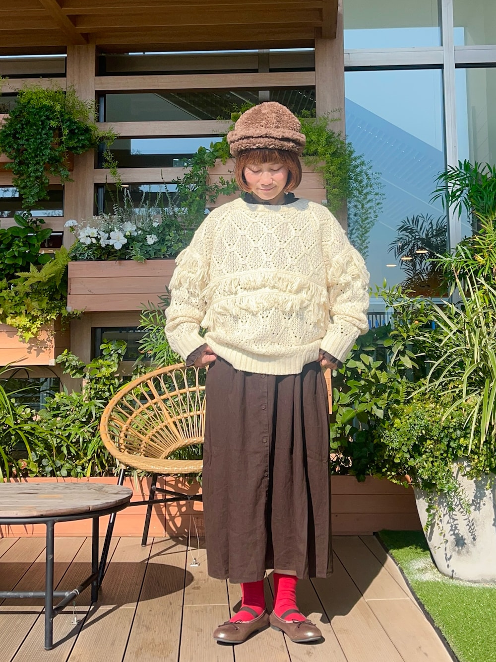 レッド系のニット/セーターを着用したレディースの春コーディネートの2枚目の写真