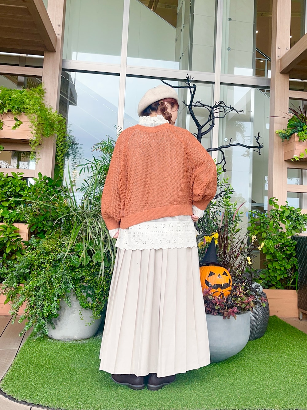 オレンジ系のカーディガン/ボレロを着用したレディースの冬コーディネートの3枚目の写真