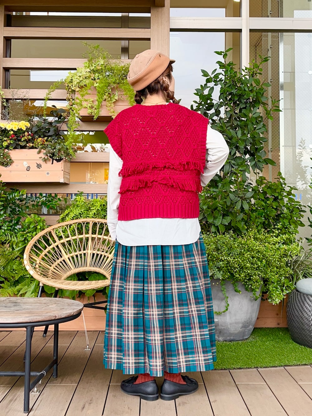 レッド系のベストを着用したレディースの春コーディネートの3枚目の写真