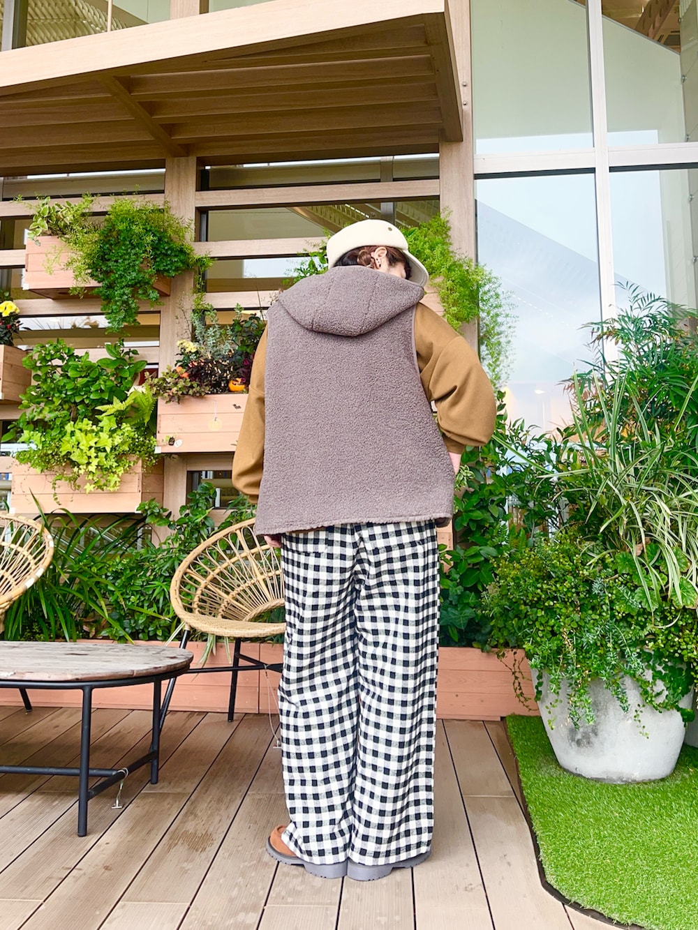 ブラウン系のベストを着用したレディースの春コーディネートの3枚目の写真