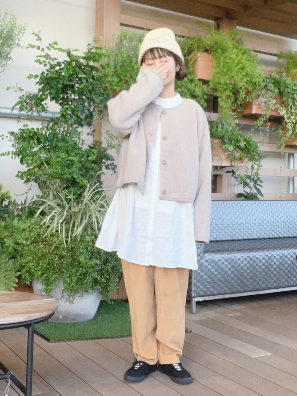 ベージュ系のブルゾン、ホワイト系のチュニック、ベージュ系のその他パンツを着用したレディースの秋コーディネートの2枚目の写真