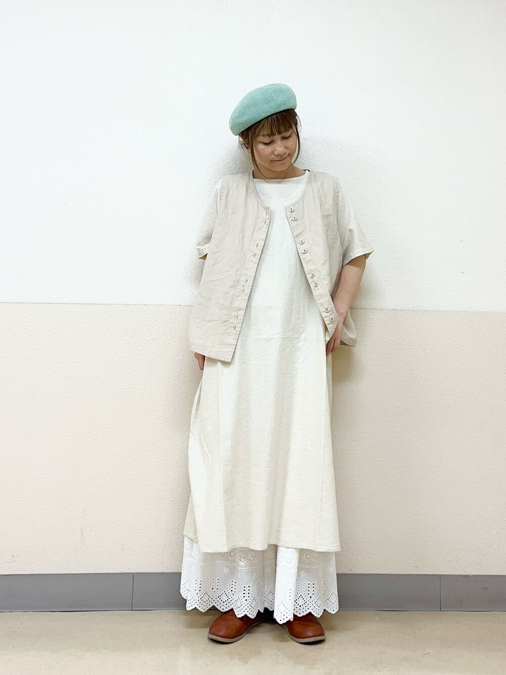 グリーン系のハットを着用したレディースの秋コーディネートの2枚目の写真