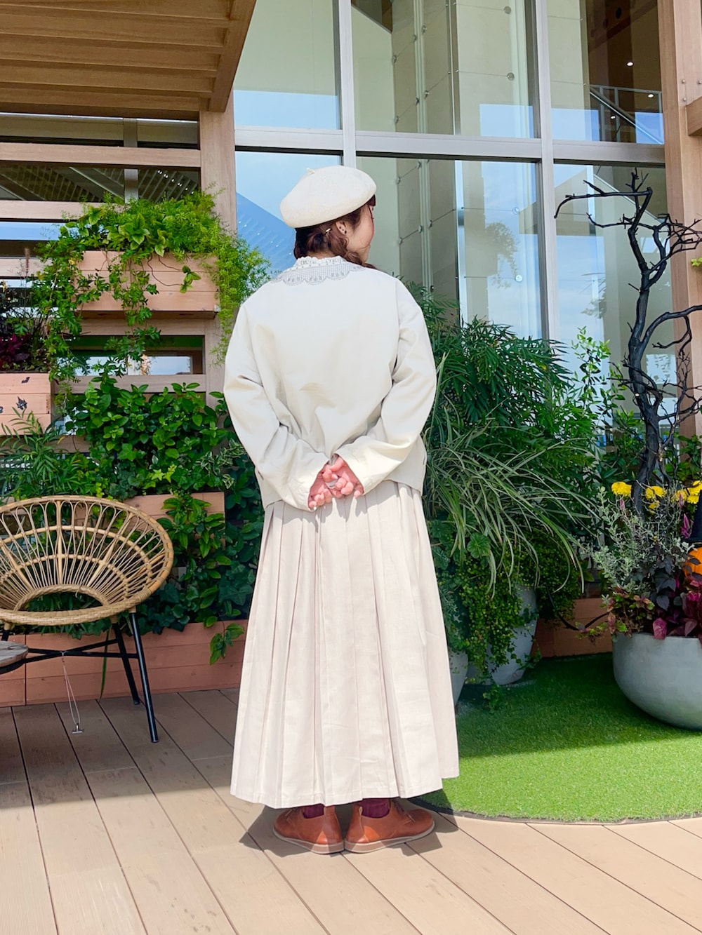 ホワイト系のノーカラージャケットを着用したレディースの冬コーディネートの3枚目の写真