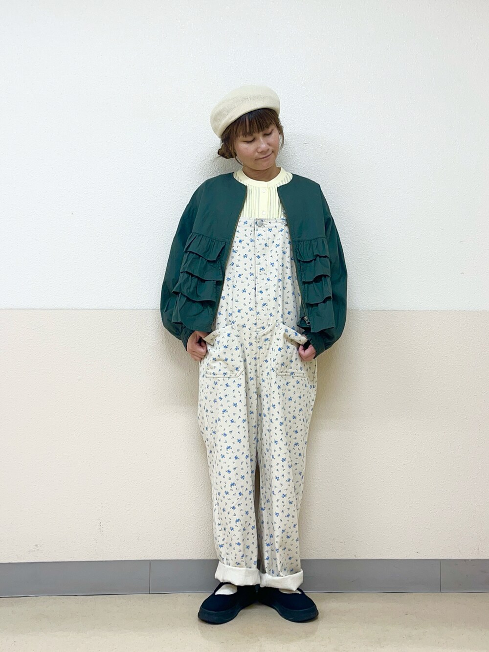 グリーン系のブルゾン、イエロー系のシャツ/ブラウス、ホワイト系のオールインワン・サロペットを着用したレディースの春コーディネートの2枚目の写真