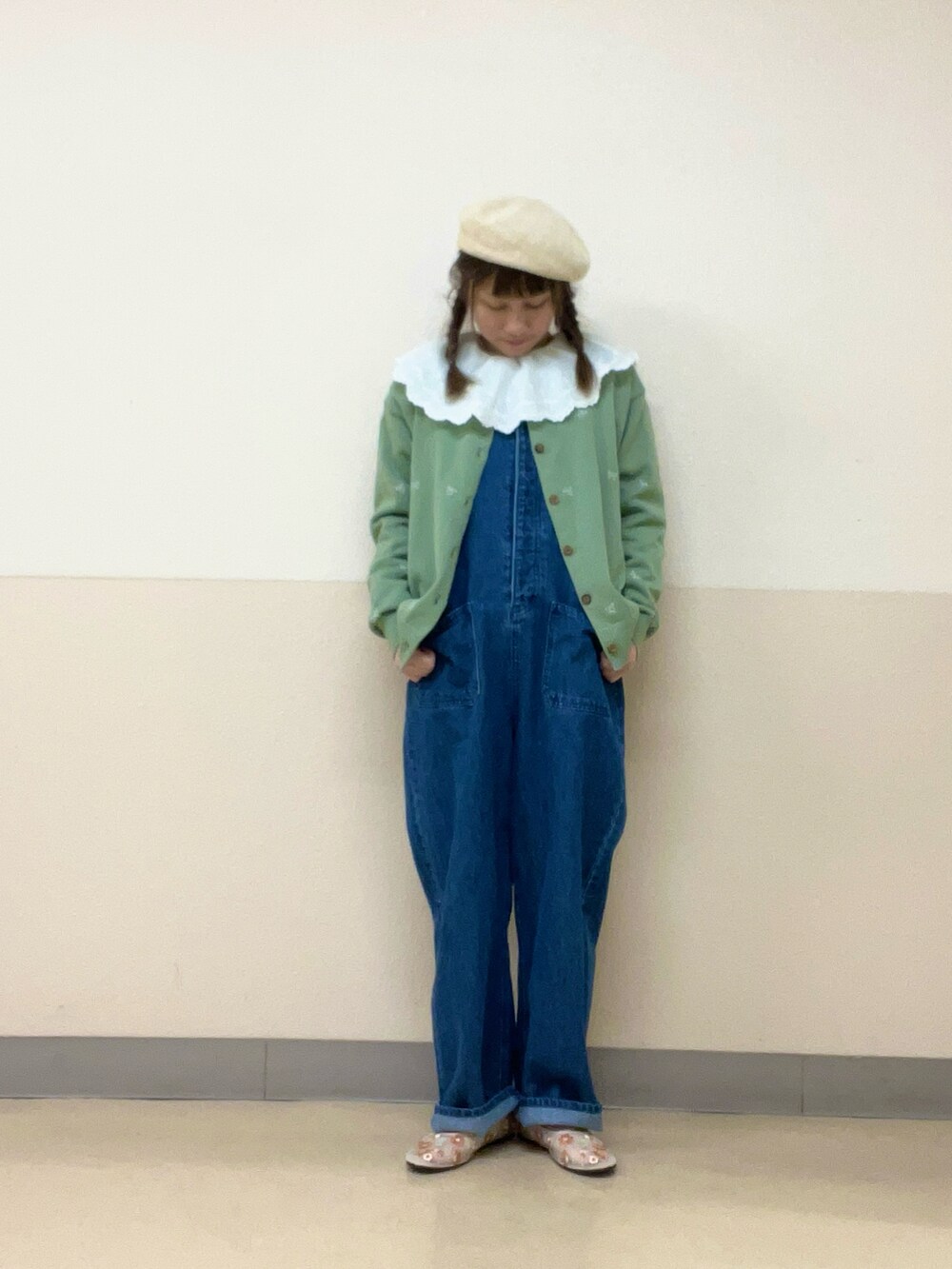 グリーン系のカーディガン/ボレロ、ホワイト系のシャツ/ブラウス、ブルー系のオールインワン・サロペットを着用したレディースの春コーディネートの2枚目の写真