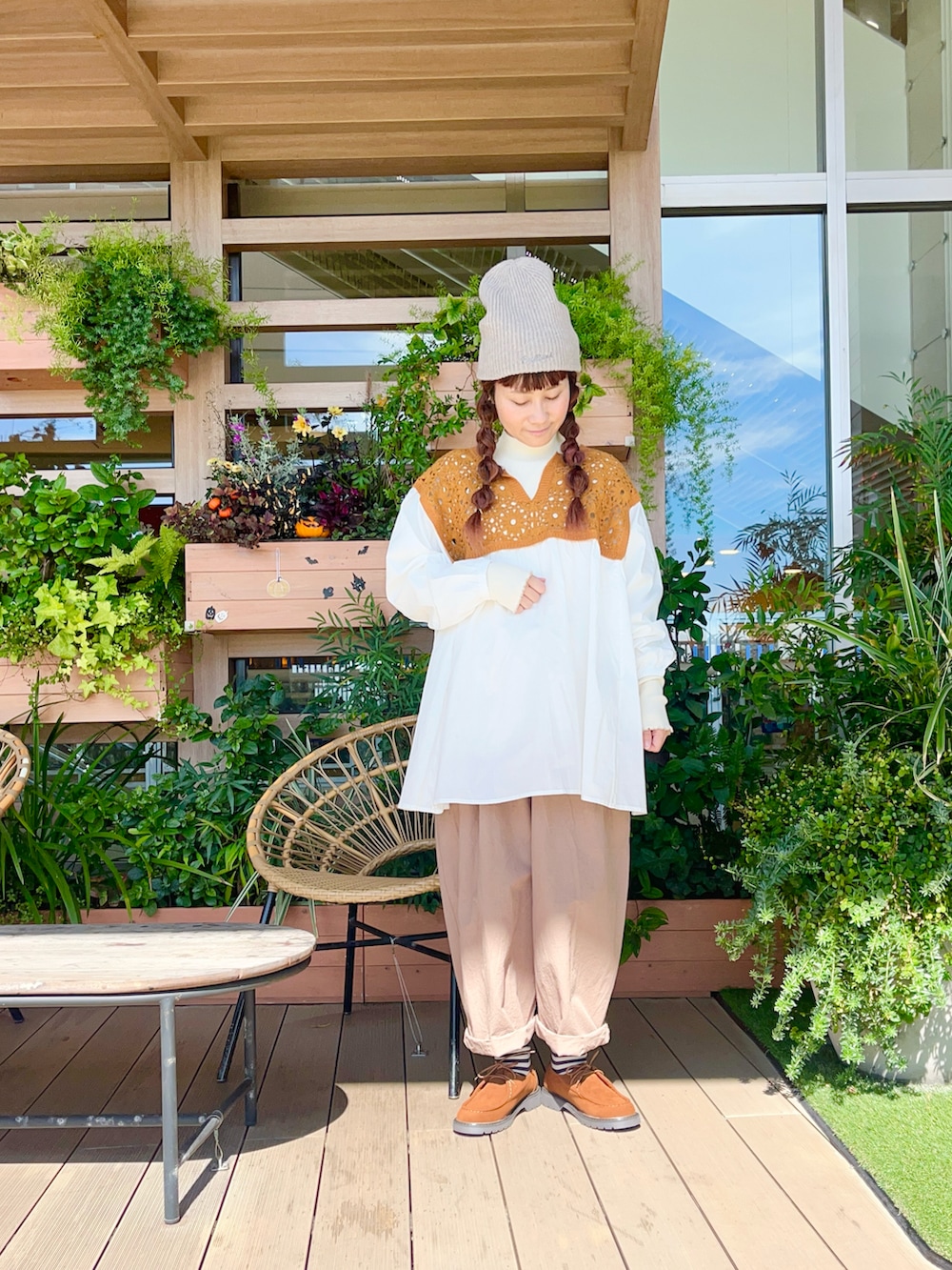 オレンジ系のチュニックを着用したレディースの春コーディネートの2枚目の写真