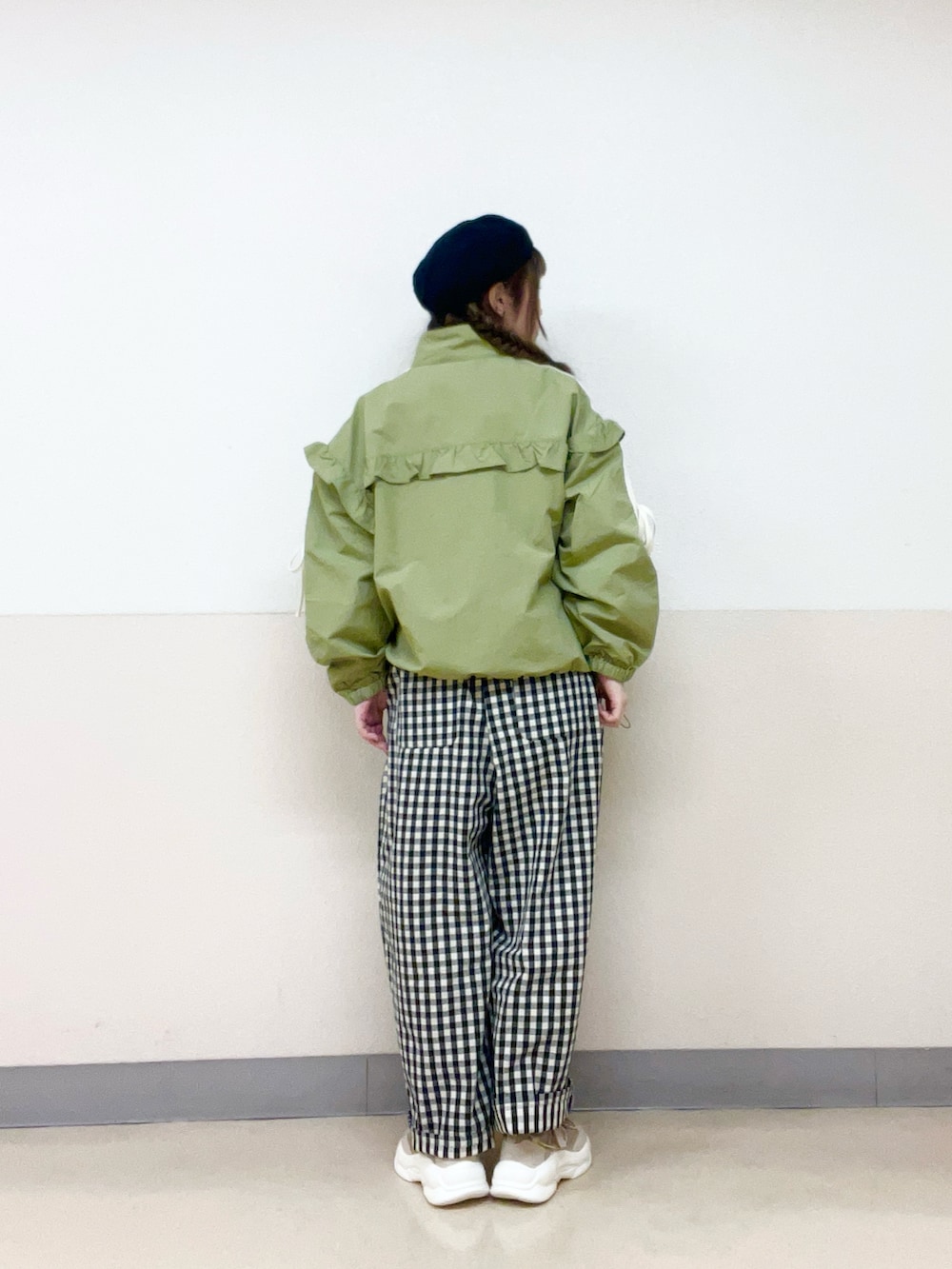 グリーン系のブルゾン、ホワイト系のパンツ、ベージュ系のスニーカーを着用したレディースの春コーディネートの3枚目の写真