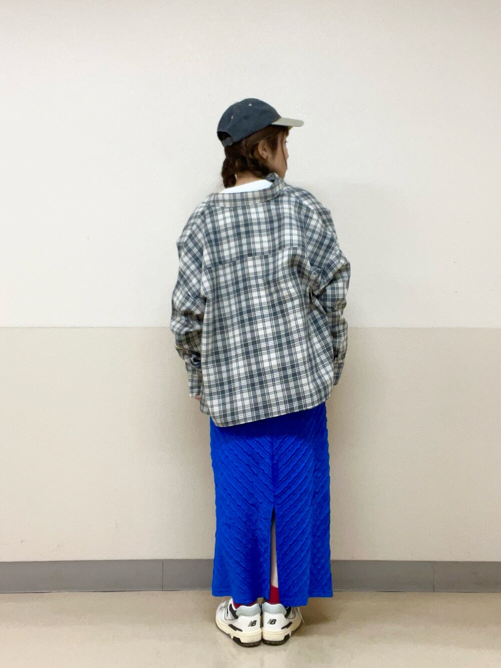 グレー系のシャツ/ブラウス、ホワイト系のベスト、ブルー系のスカートを着用したレディースの春コーディネートの2枚目の写真