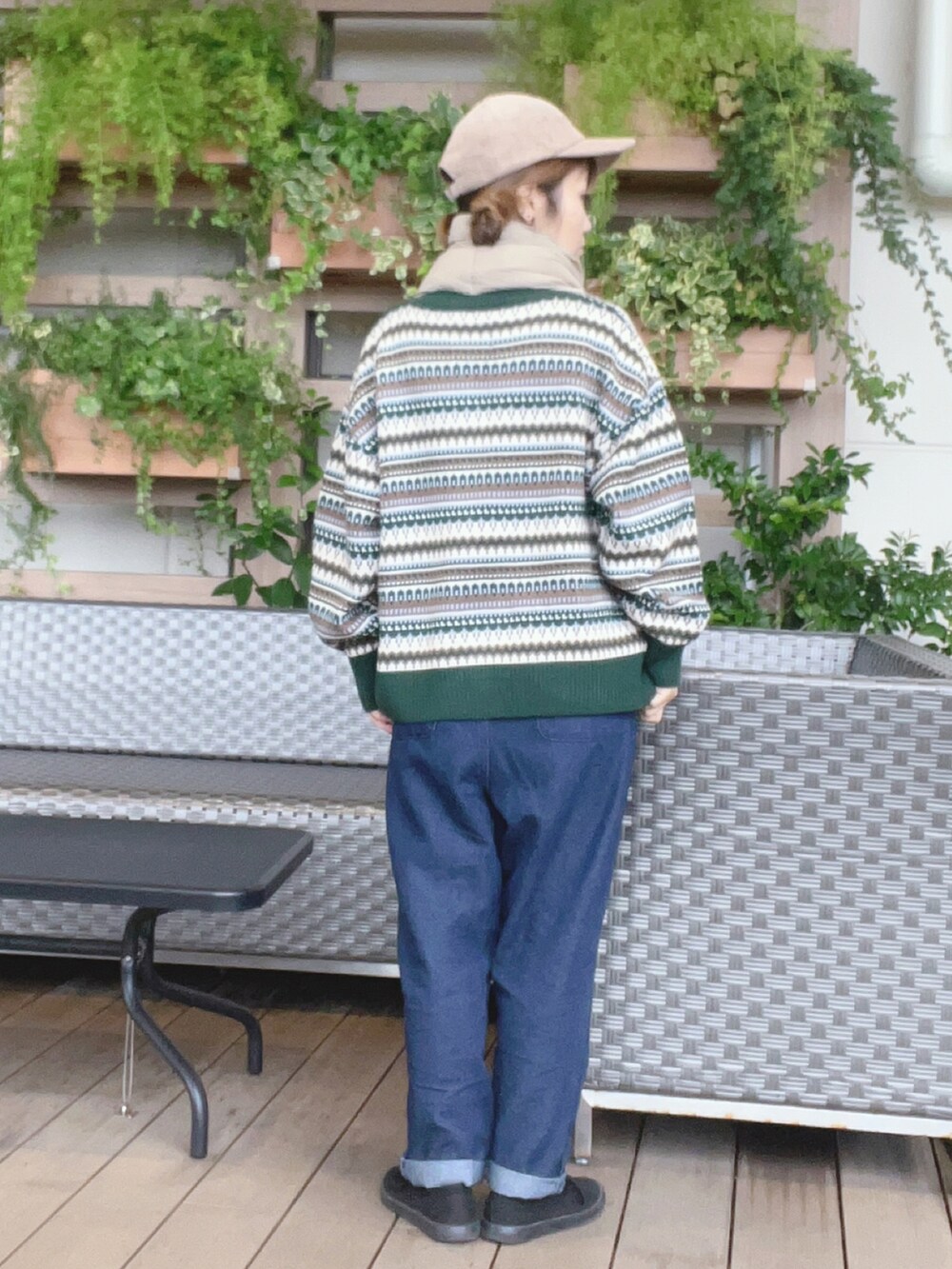 ブラック系のスニーカー、グリーン系のニット/セーター、ブルー系のその他パンツを着用したレディースの秋コーディネートの2枚目の写真