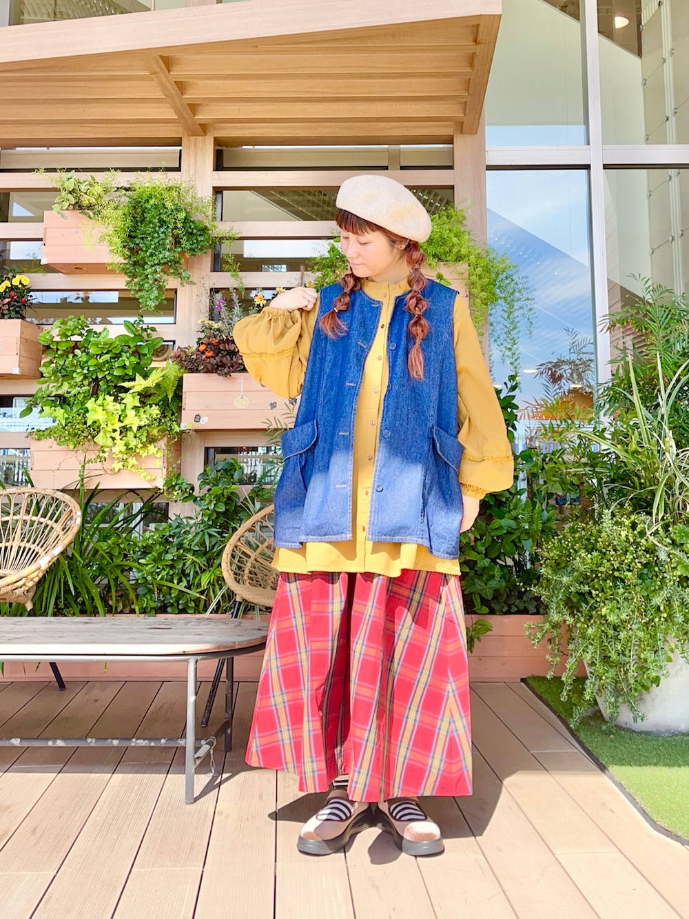 ブルー系のベストを着用したレディースの春コーディネートの2枚目の写真