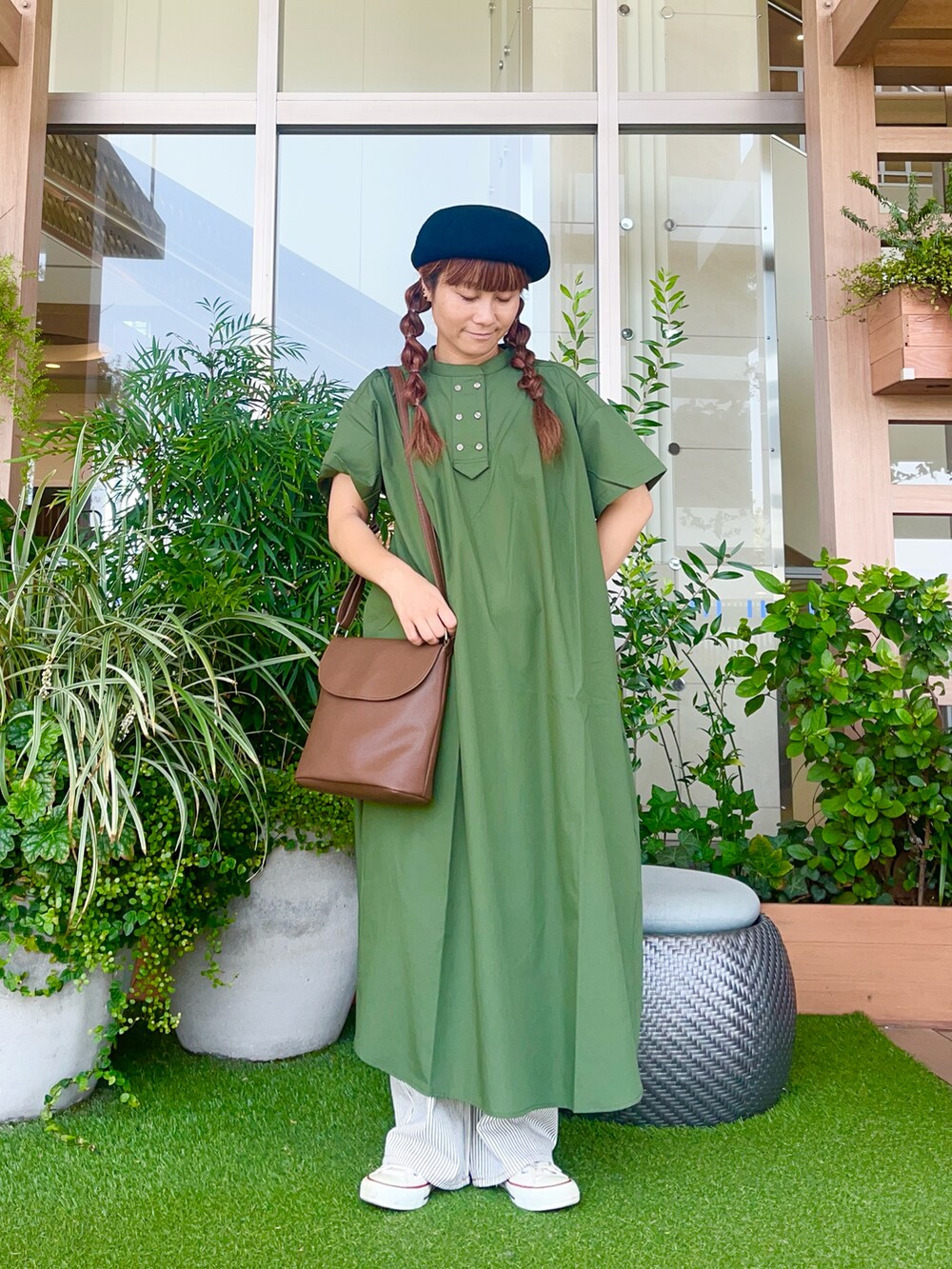 グリーン系のワンピースを着用したレディースの冬コーディネートの2枚目の写真