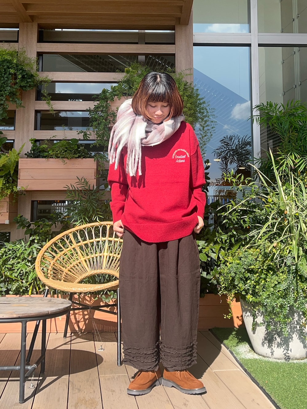 レッド系のニット/セーターを着用したレディースの春コーディネートの2枚目の写真