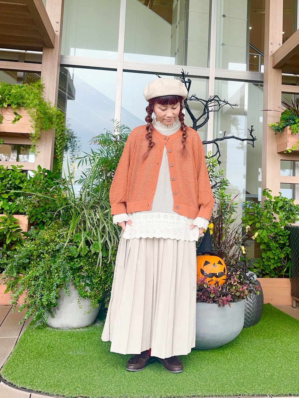 オレンジ系のカーディガン/ボレロを着用したレディースの冬コーディネートの2枚目の写真