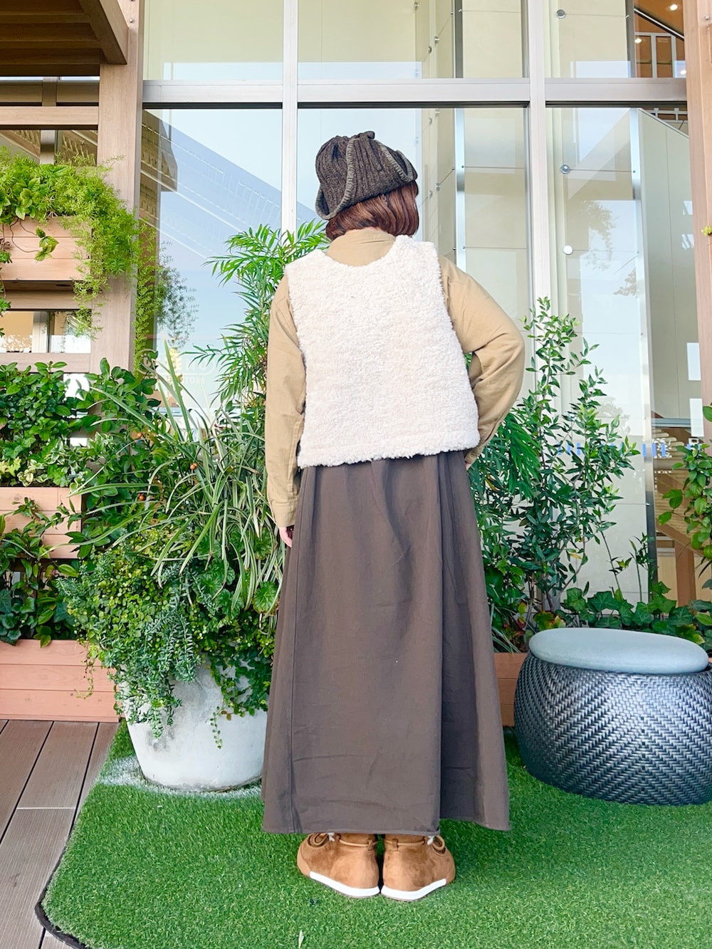 ホワイト系のベストを着用したレディースの春コーディネートの3枚目の写真