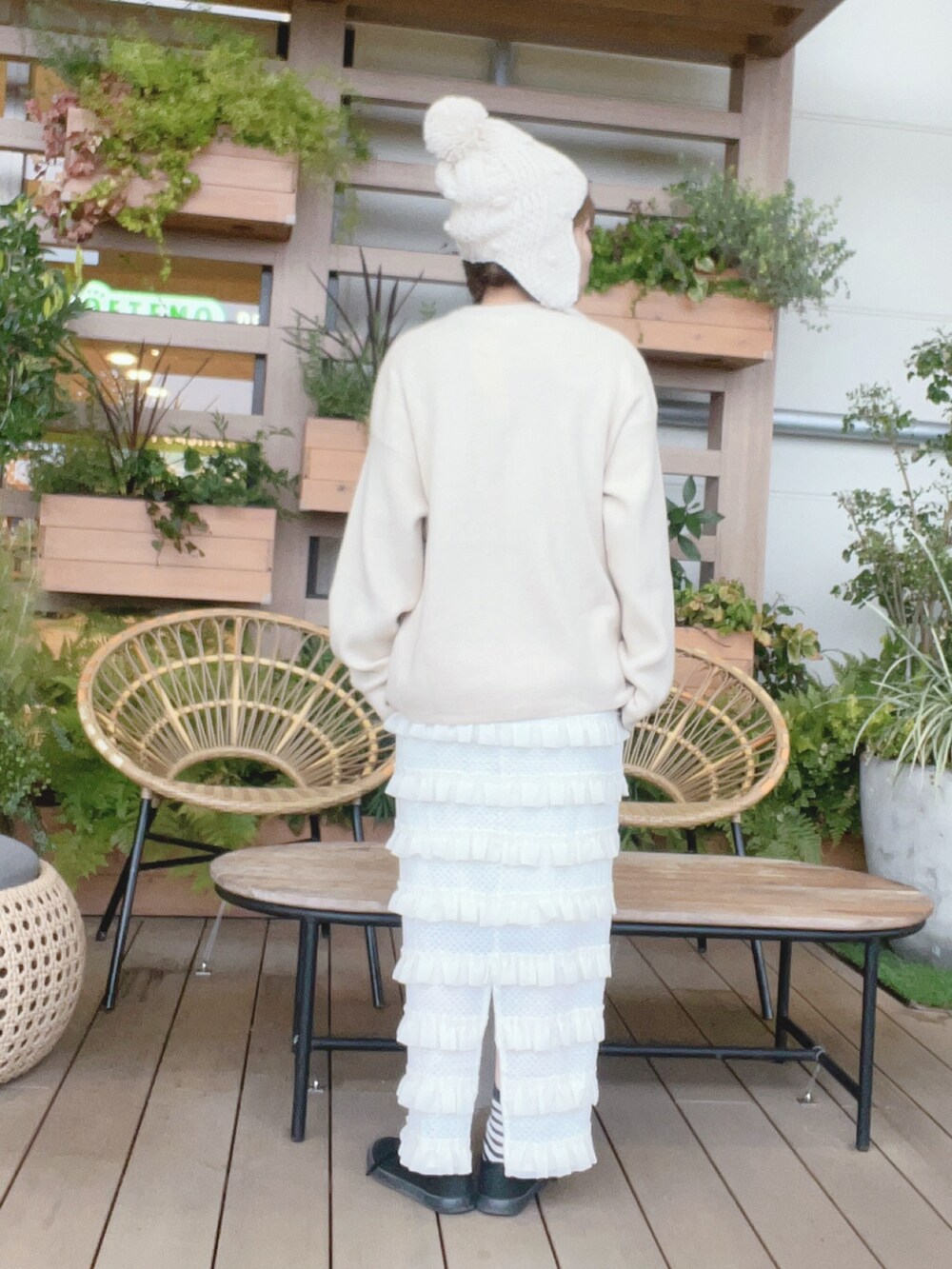 ホワイト系のニット/セーター、ホワイト系のスカート、ブラック系のスニーカーを着用したレディースの冬コーディネートの3枚目の写真