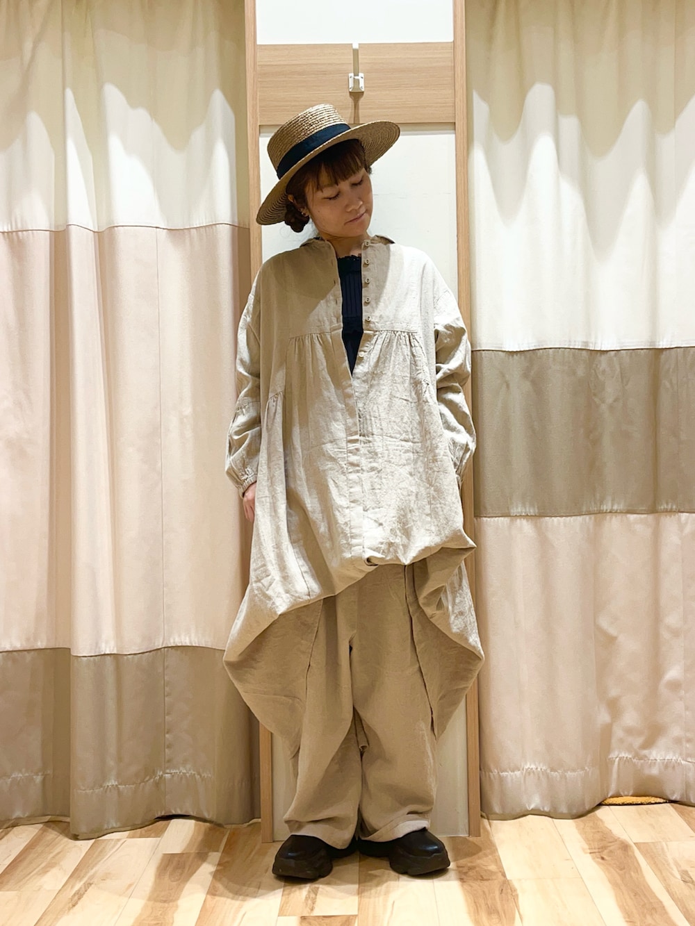 ベージュ系のワンピース、ベージュ系のその他パンツ、ブラウン系のハットを着用したレディースの春コーディネートの2枚目の写真