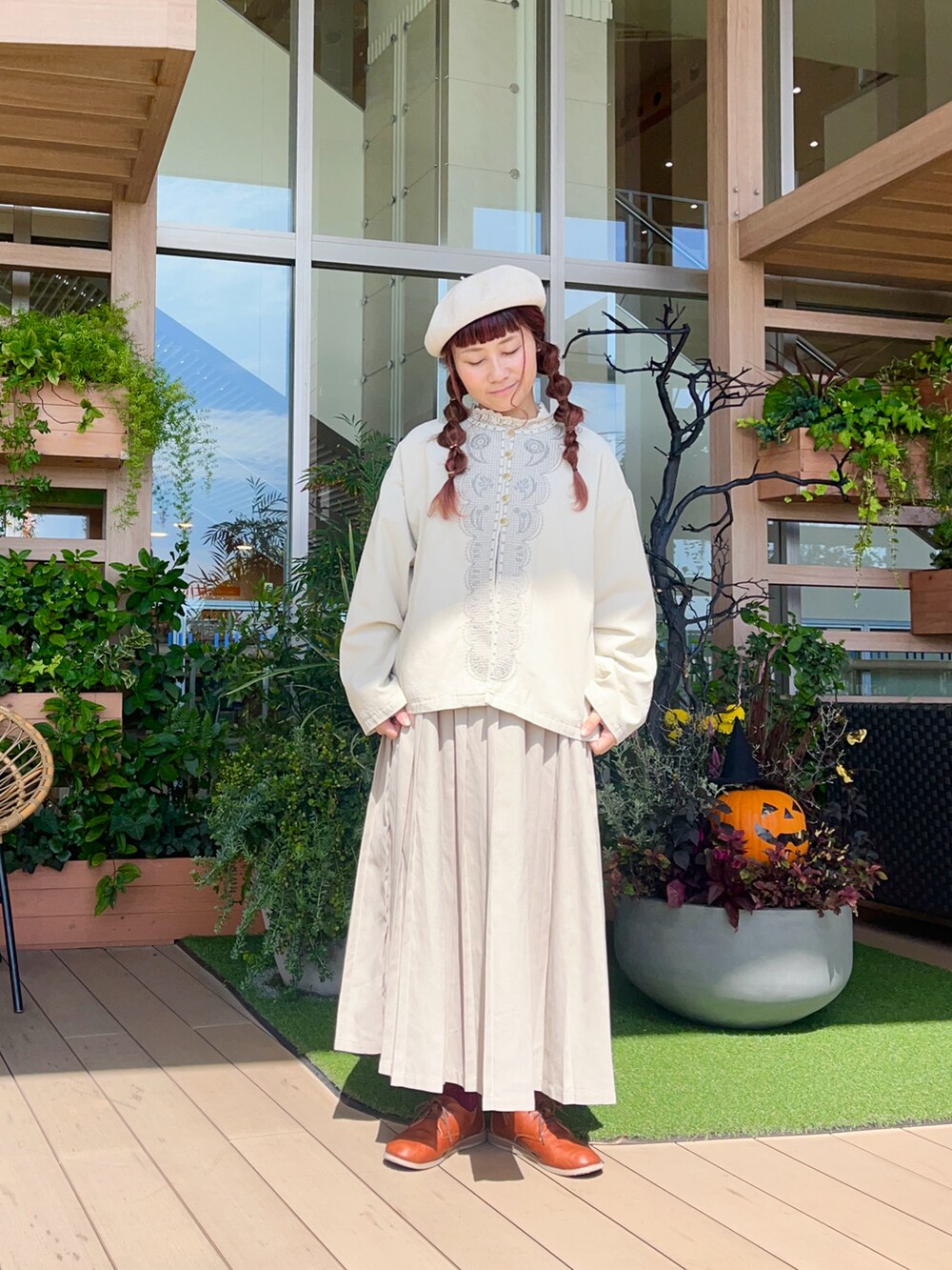 ホワイト系のノーカラージャケットを着用したレディースの冬コーディネートの2枚目の写真