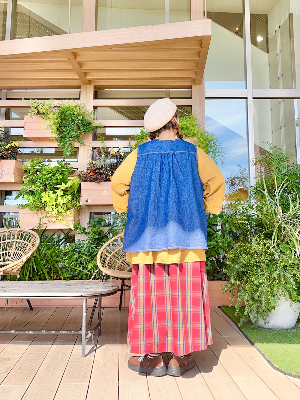 ブルー系のベストを着用したレディースの春コーディネートの3枚目の写真