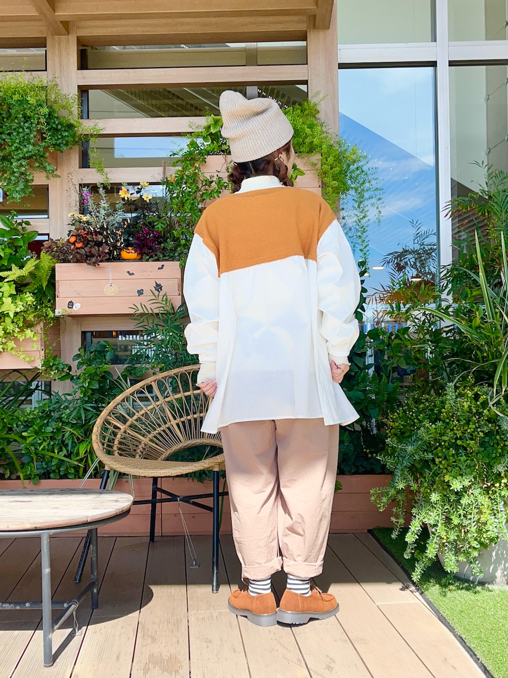 オレンジ系のチュニックを着用したレディースの春コーディネートの3枚目の写真