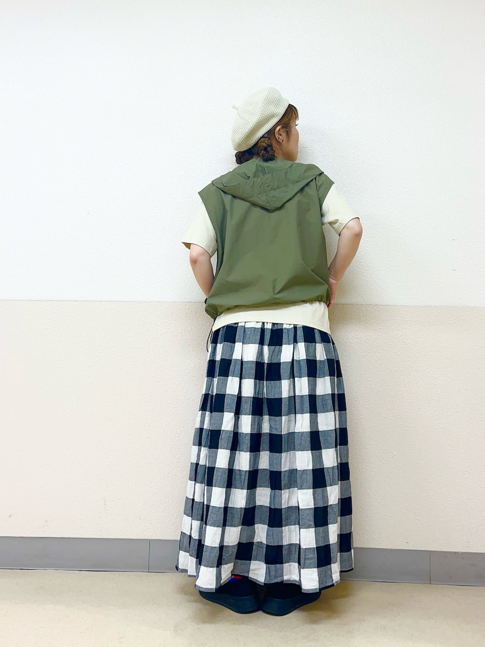 グリーン系のベストを着用したレディースの秋コーディネートの3枚目の写真