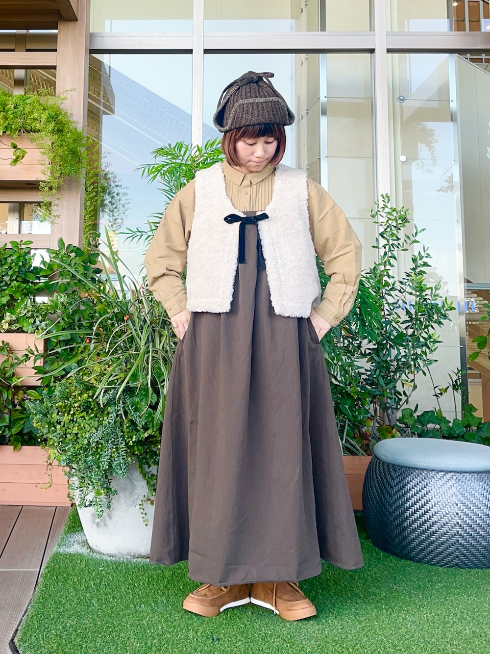 ホワイト系のベストを着用したレディースの春コーディネートの2枚目の写真