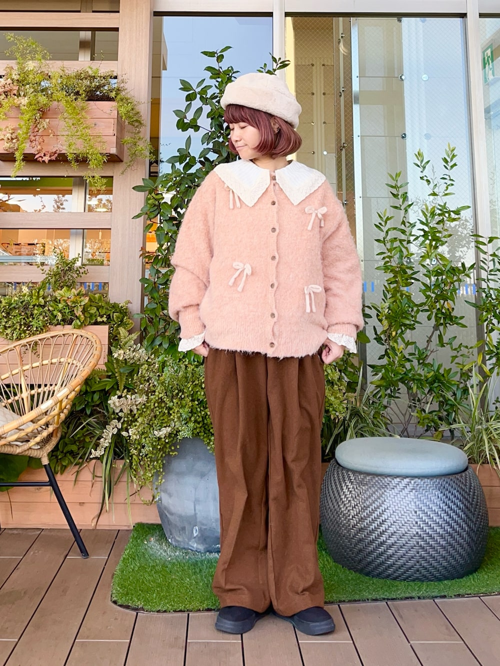 オレンジ系のカーディガン/ボレロを着用したレディースの春コーディネートの2枚目の写真