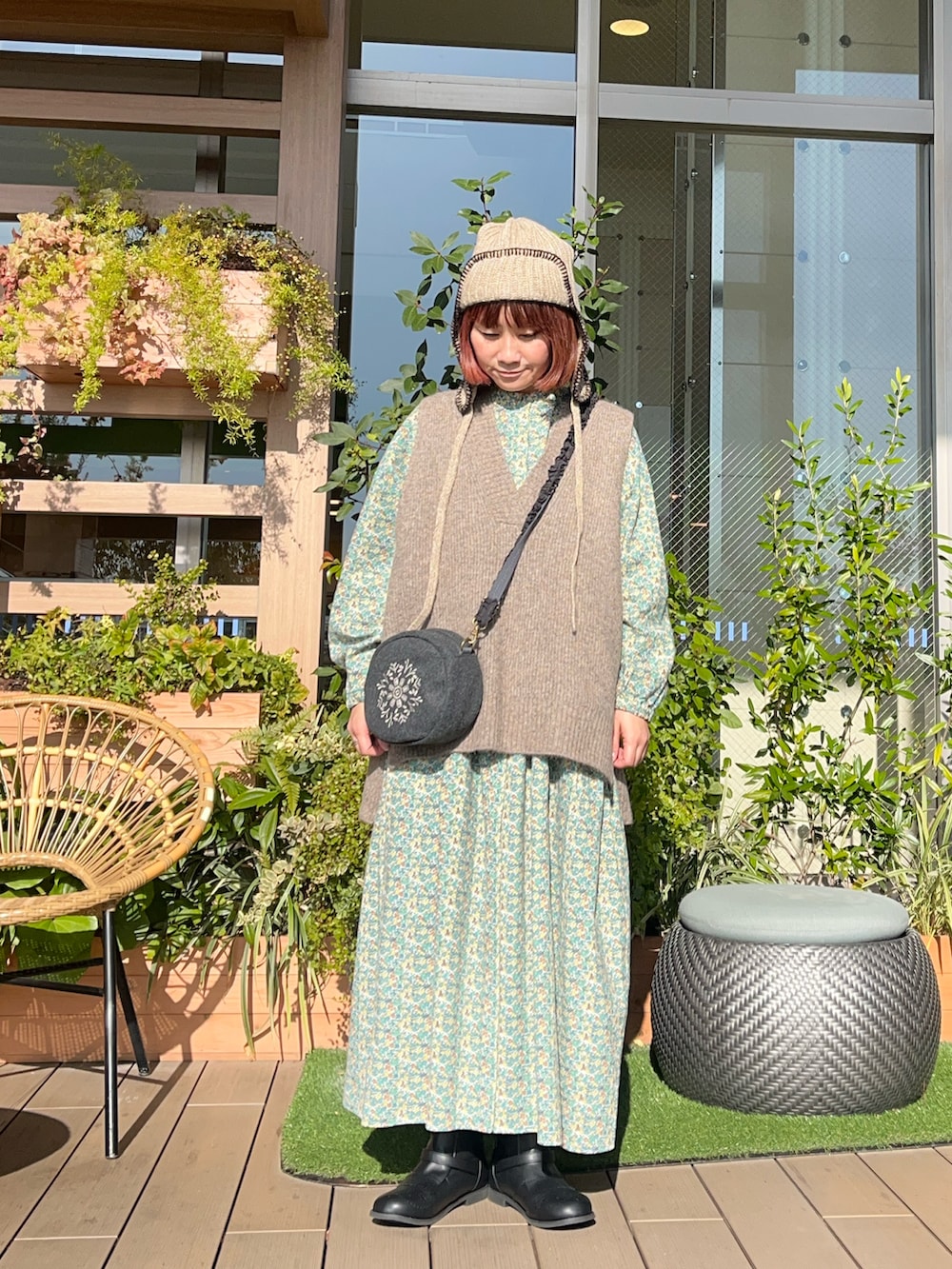グリーン系のワンピースを着用したレディースの春コーディネートの2枚目の写真