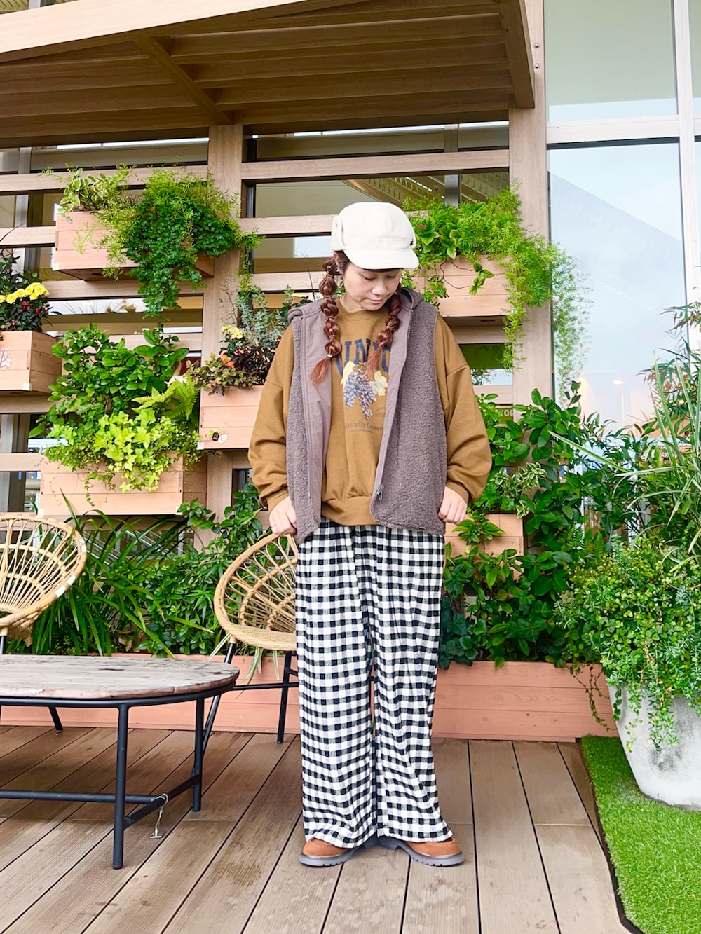 ブラウン系のベストを着用したレディースの春コーディネートの2枚目の写真