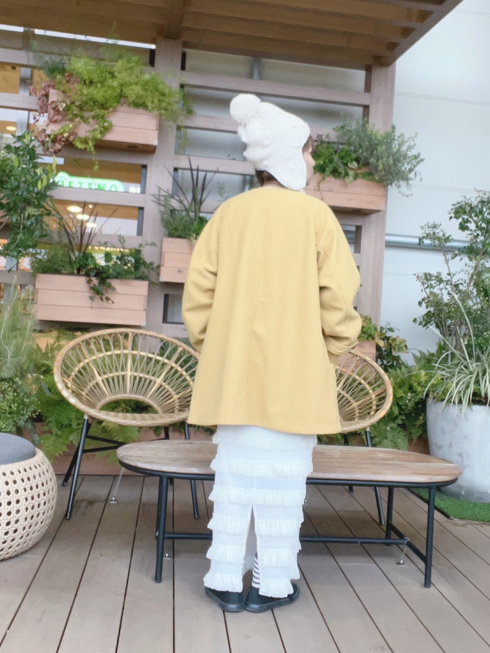 イエロー系のその他アウター、ホワイト系のニット/セーター、ホワイト系のスカートを着用したレディースの冬コーディネートの3枚目の写真