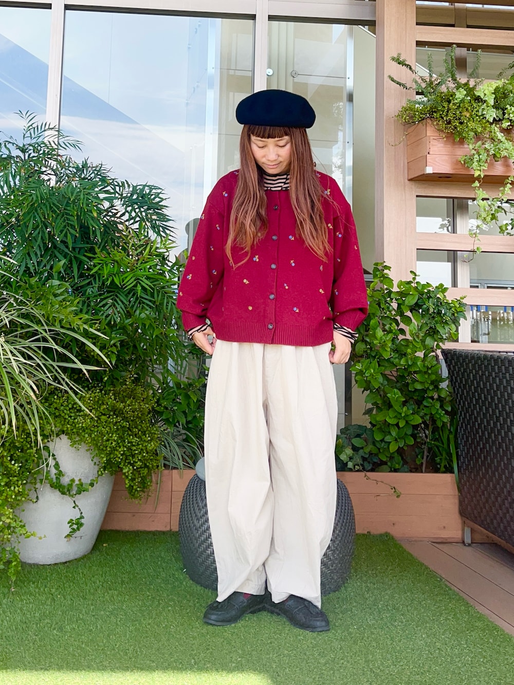 レッド系のカーディガン/ボレロを着用したレディースの冬コーディネートの2枚目の写真