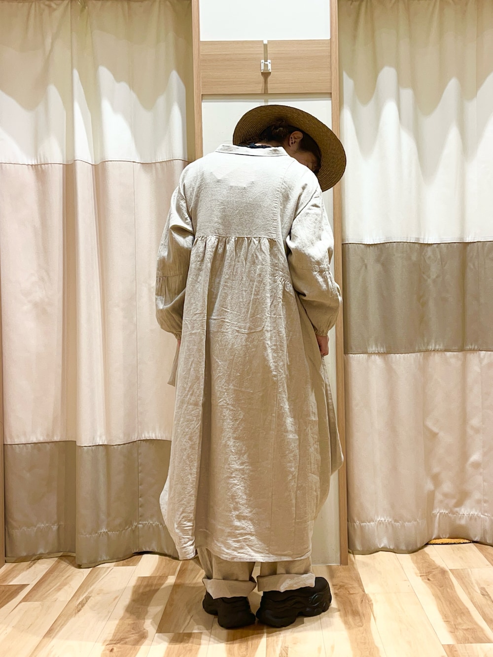 ベージュ系のワンピース、ベージュ系のその他パンツ、ブラウン系のハットを着用したレディースの春コーディネートの3枚目の写真