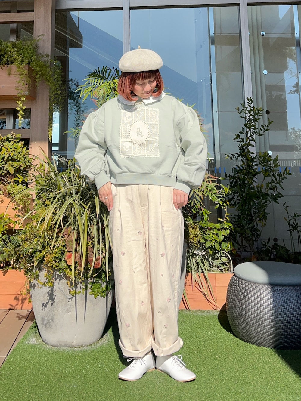 グリーン系のトップスを着用したレディースの夏コーディネートの2枚目の写真