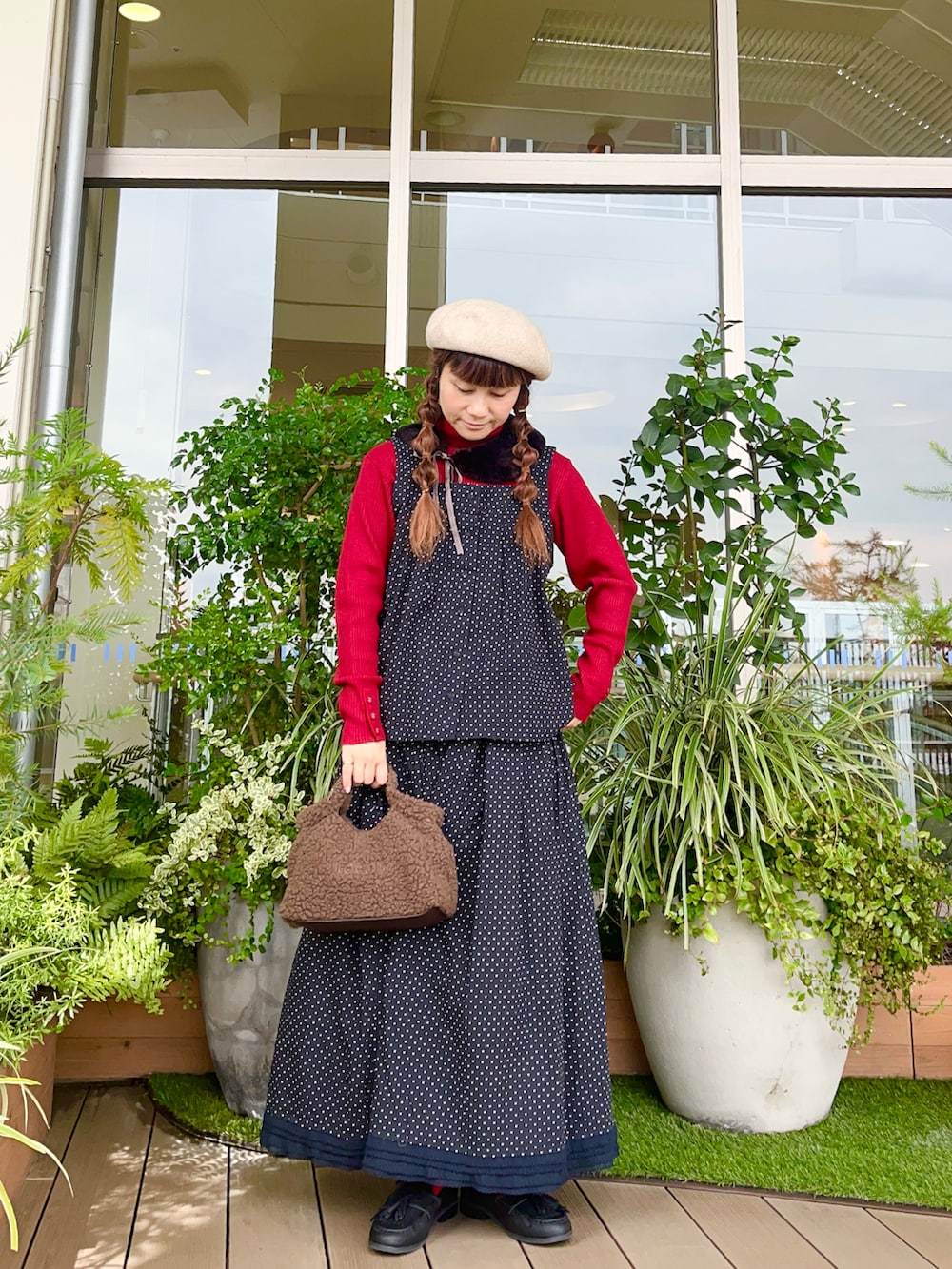 レッド系のニット/セーターを着用したレディースの春コーディネートの2枚目の写真