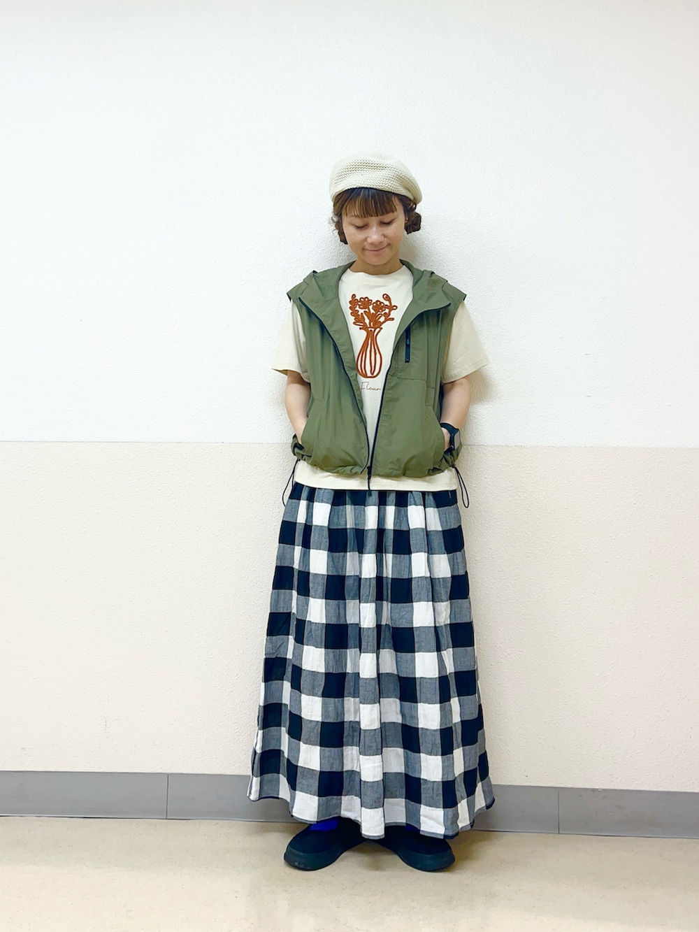 グリーン系のベストを着用したレディースの秋コーディネートの2枚目の写真