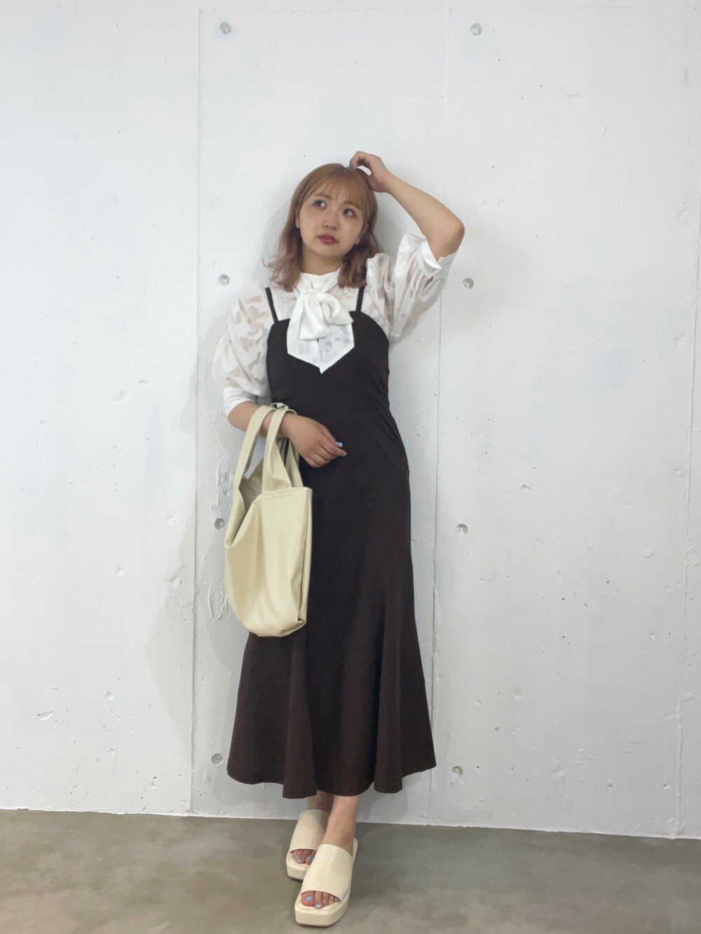 ホワイト系のシャツ/ブラウス、ブラウン系のジャンパースカート、ホワイト系のトートバッグを着用したレディースの夏コーディネートの2枚目の写真